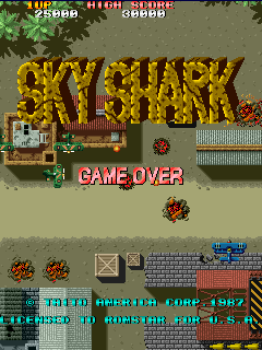 Sky Shark attract mode: the SKY SHARK logo in carved stone over an occupied airfield, tanks and gun emplacements below, the player's biplane at the lower right