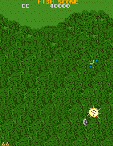 Xevious over Area 1: the Solvalou low over a dense green forest, an enemy Toroid above it and a ground target going up in a yellow blast, with the score line across the top
